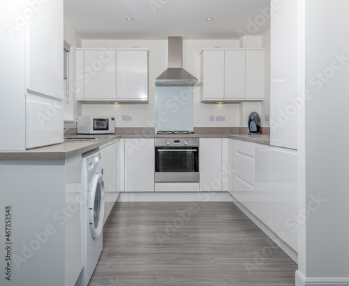 Modern Generic New Build Kitchen in High Gloss White and Grey Laminate Link Flooring.