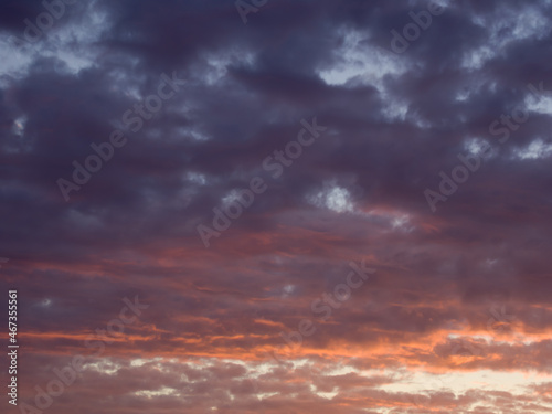 Dramatic cloudscape at sunset. Fancy clouds in the sky. Twilight heaven with orange light.
