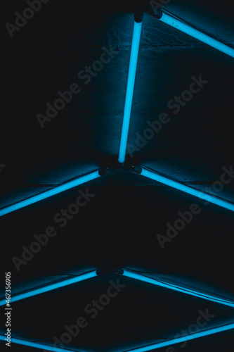 Blue fluorescent lamps  mounted on a brick wall. A gas charged luminaire. Background image, abstract, urban lighting