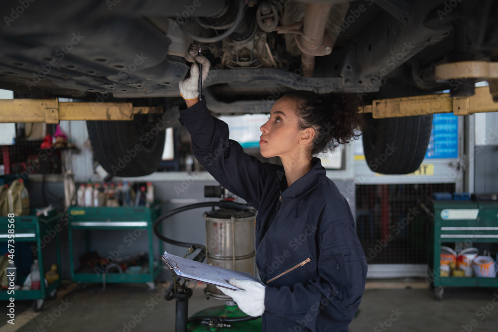 Mechanic changing engine, service car workshop automobile. professional female shop maintenance