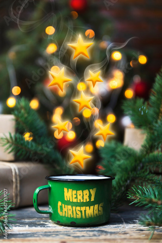 Coffee in a tin mug with stars comming out of it on the decorated rustic table. Merry Chritmas and Happy New Year