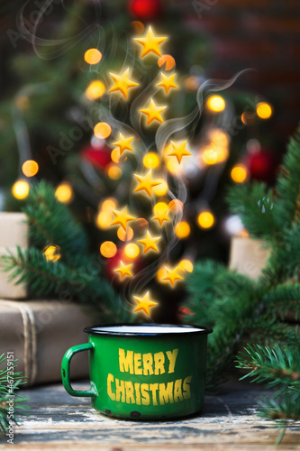 Coffee in a tin mug with stars comming out of it on the decorated rustic table. Merry Chritmas and Happy New Year