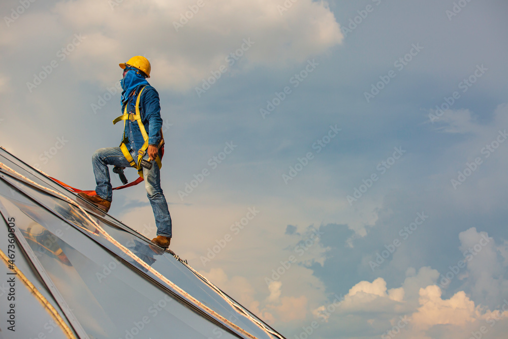 Male workers rope access height safety connecting with a knot safety harness, clipping into roof construction site oil tank dome Male workers rope access height safety connecting with a knot safety harness, clipping into roof construction site oil tank dome