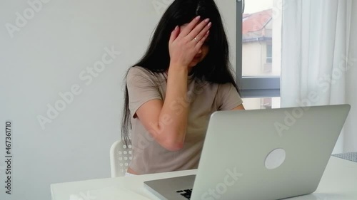 Worried worried young freelance woman looking at laptop screen, embarrassed, nervous about lost money. Anxiously upset girl trader, bitcoin rate has fallen