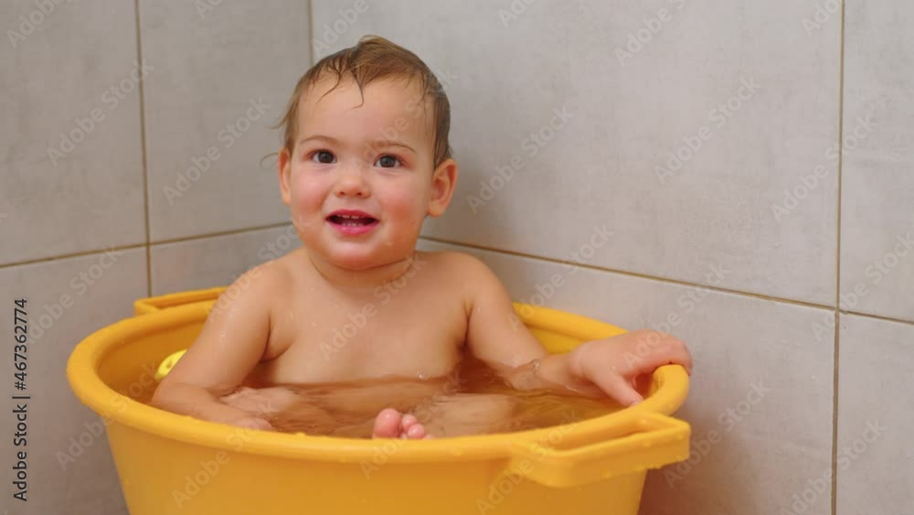 Slow motion video of adorable baby girl sitting and smiling at bath. Slow motion video of adorable baby girl sitting and smiling at bath.