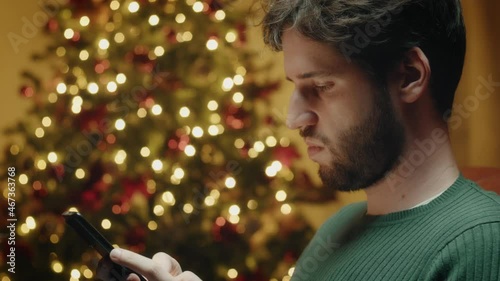 Giovane ragazzo manda messaggi sul telefono a Natale photo