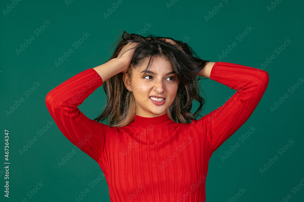 Portrait of young beuatiful girl, student in bright red sweater isolated on green studio backgroud. Portrait of young beuatiful girl, student in bright red sweater isolated on green studio backgroud.