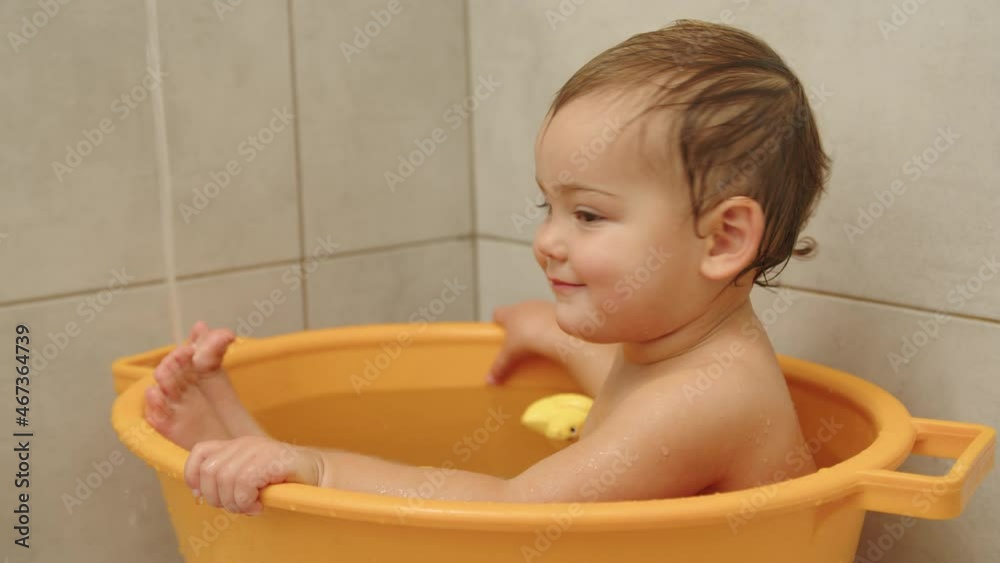 Slow motion video of adorable baby girl sitting and smiling at bath. Slow motion video of adorable baby girl sitting and smiling at bath.