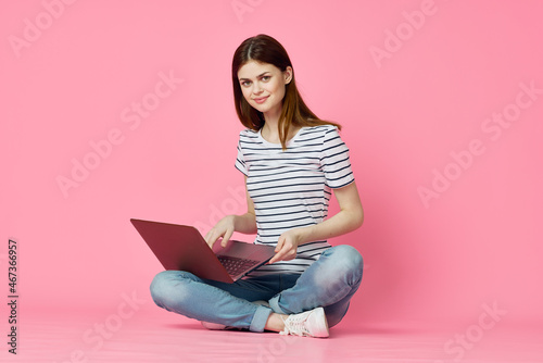 woman with laptop on pink background online shopping entertainment