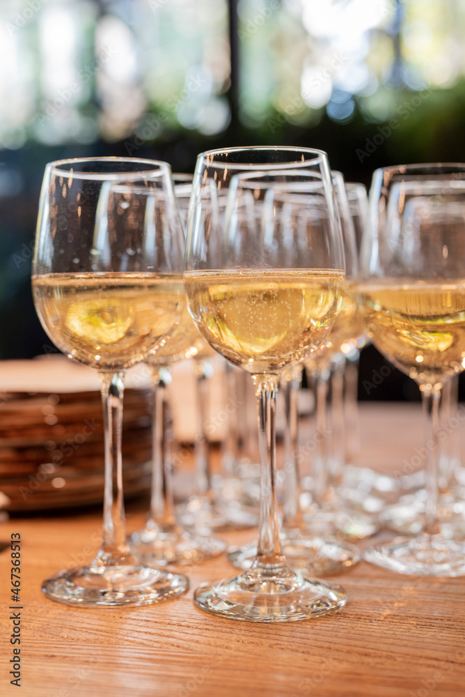 a lot of glasses with white wine in a restaurant at a buffet or banquet for a holiday