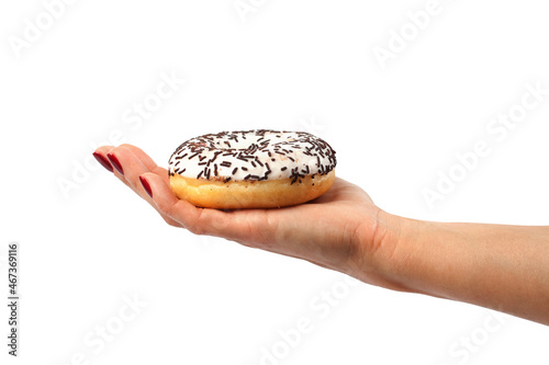 the girl holds a doughnut with chocolate crumbs isolated on a white background. Woman's hand, dessert, sweet pastries.