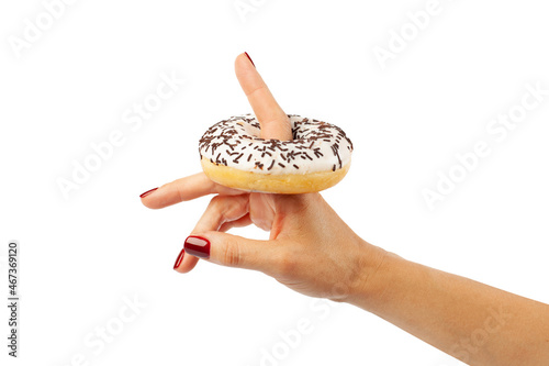 the girl holds a doughnut with glaze and chocolate crumb on her finger isolated on a white background. Dessert, sweetness, delicious, pastries for tea, coffee