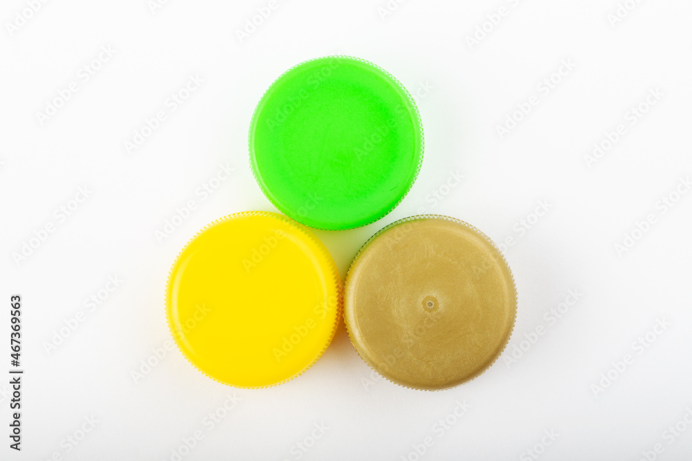 Pile of colored plastic caps on white background. Recycling concept. Pile of colored plastic caps on white background. Recycling concept.
