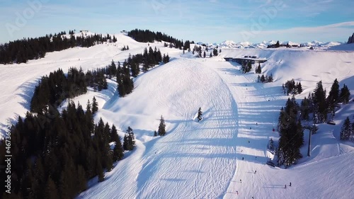 Ski in the Alps with ski lift and people skiing on the slope. Aerial view photo