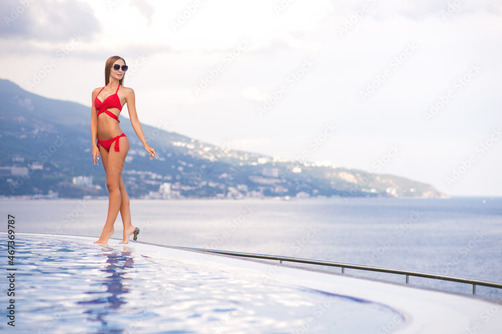 Beautiful woman in bikini sunbathing at the seaside. Summer time, beach, pool, vacation concept Beautiful woman in bikini sunbathing at the seaside. Summer time, beach, pool, vacation concept