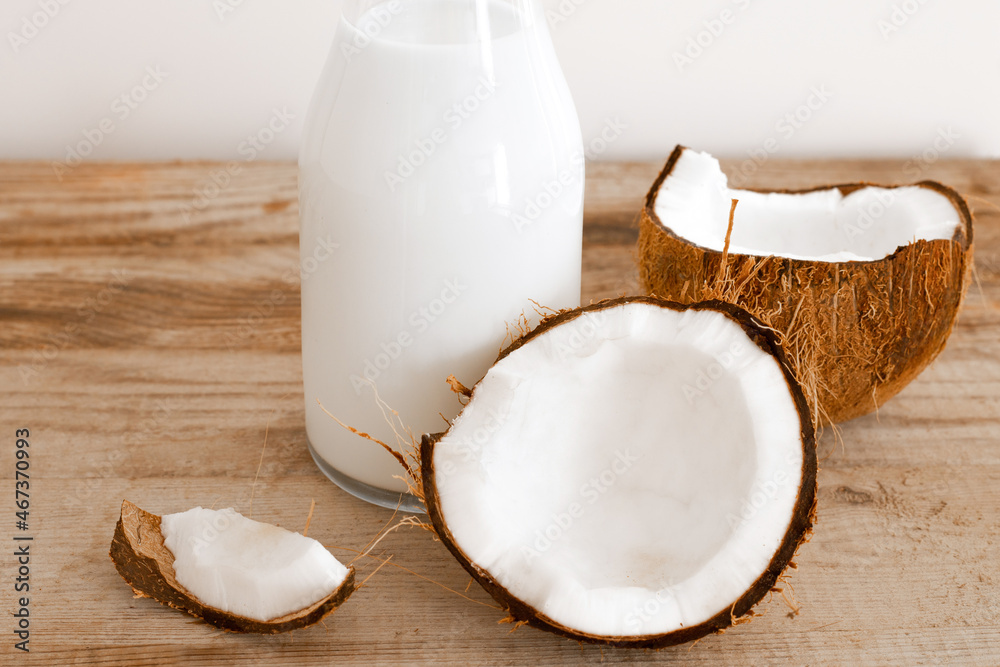 Fresh coconut milk in glass bottle, vegan non dairy healthy drink. Wooden table, close-up. Fresh coconut milk in glass bottle, vegan non dairy healthy drink. Wooden table, close-up.