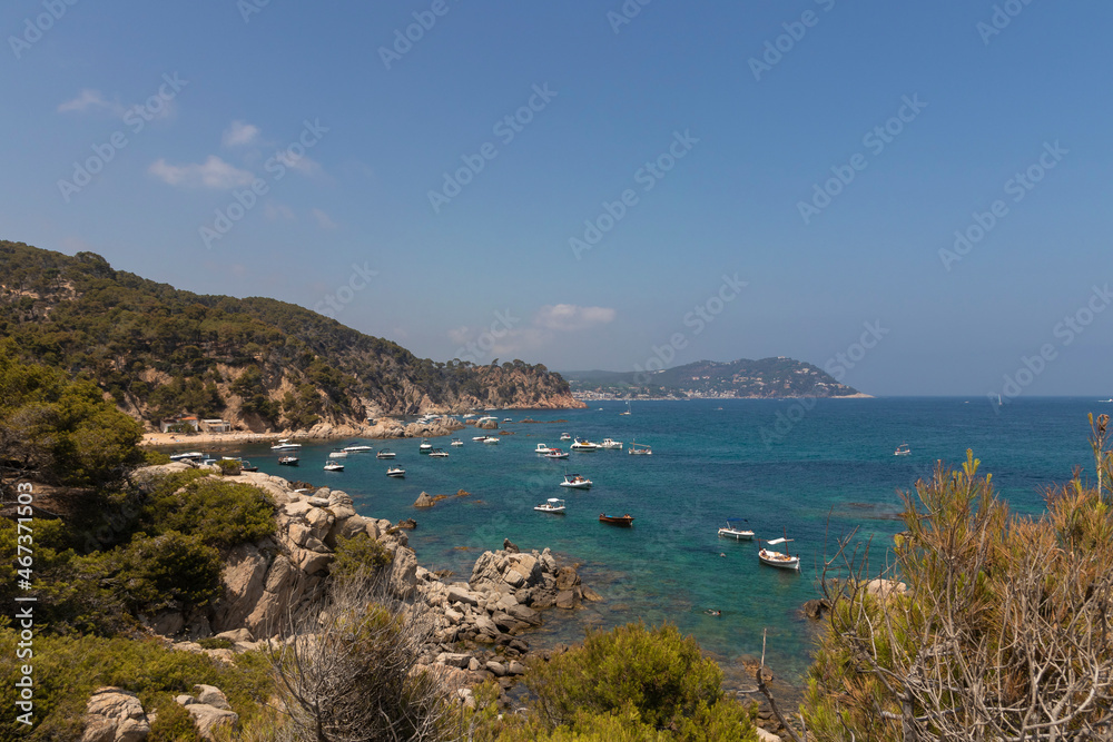 bay full of tourist boats on the costa brava on a sunny summer day