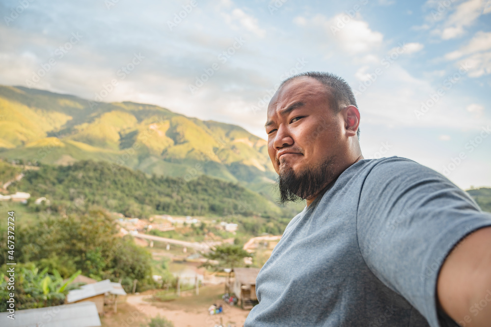 Asian fat traveler selfie himself with beautiful mountain view of Sapan Village At nan Thailand.Sapan is Small and tranquil Village in the mountain.Thailand destination travel Asian fat traveler selfie himself with beautiful mountain view of Sapan Village At nan Thailand.Sapan is Small and tranquil Village in the mountain.Thailand destination travel