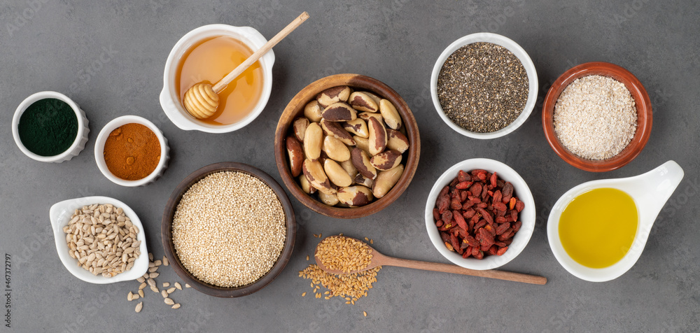 Assorted superfoods in spoons over stone background. Chia, quinoa, oat, linseed, honey, spirulina and others Assorted superfoods in spoons over stone background. Chia, quinoa, oat, linseed, honey, spirulina and others