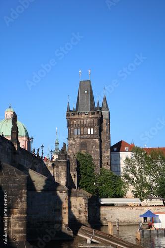 The majestic Charles Bridge over the serene Vltava River against the blue sky