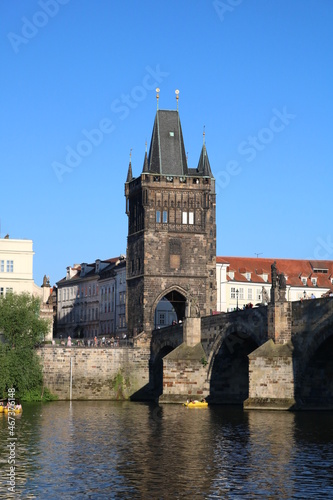 The majestic Charles Bridge over the serene Vltava River on a clear sunny day