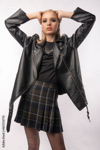 Young girl posing in a skirt and leather jacket. Makeup, top model, fashion, popularity.