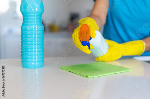 Crop housekeeper spraying detergent on cleaning cloth photo
