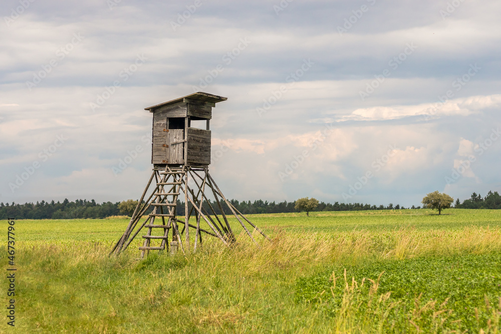 hunting blind on a field, in the background the sky with white clouds hunting blind on a field, in the background the sky with white clouds