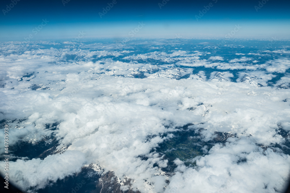 White heavy clouds in the blue sky. Panoramic cloudscape above the clouds.