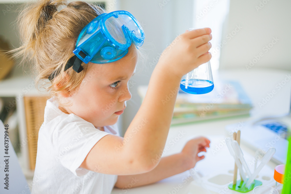 Science. Little cute girl sets up experiments at home, colored liquids, laboratory child's installation. Science. Little cute girl sets up experiments at home, colored liquids, laboratory child's installation.