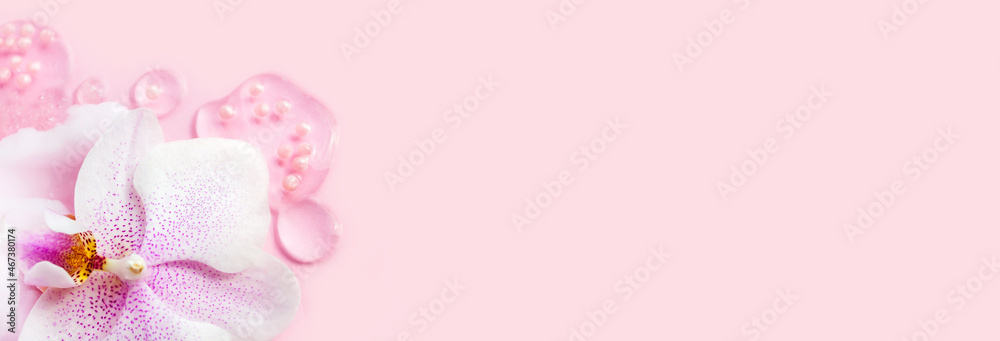 Transparent serum smear, orchid flower closeup in beautiful style on Pink background. Beauty skin care product banner, copy space