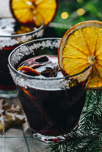 Swedish glögg in glass on dark background. Traditional Nordic drink. Mulled wine with spices, orange and raisins.