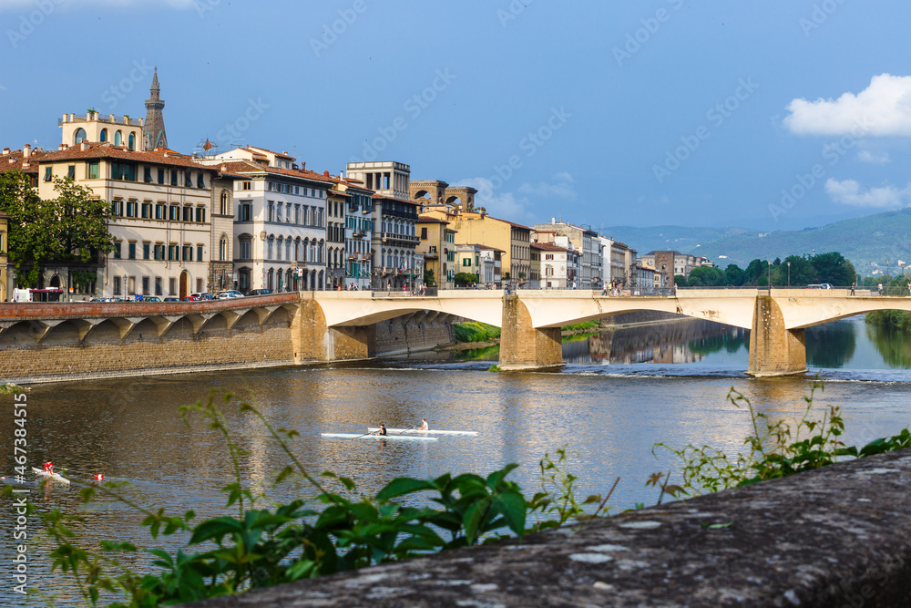 Ponte alle Grazie, Florence, Italy. Kayak athletes ride along the Arno river