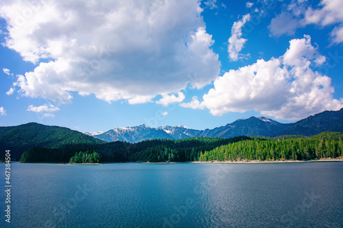 The Eibsee in Garmisch-Partenkirchen on an autumn day with snow-capped mountain peaks and clouds in the sky.