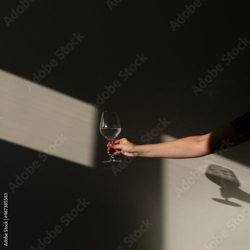  A glass of water on a white background with a shadow. Chiaroscuro from the window. Close-up, copy space