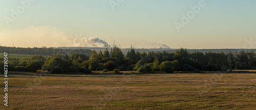 factory with smoking chimneys at sunset background
