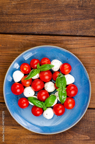 Delicious Italian caprese salad with basil, mozzarella and cherry tomatoes. Studio Photo.
