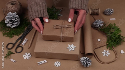 Woman packing Christmas gifts in brown paper