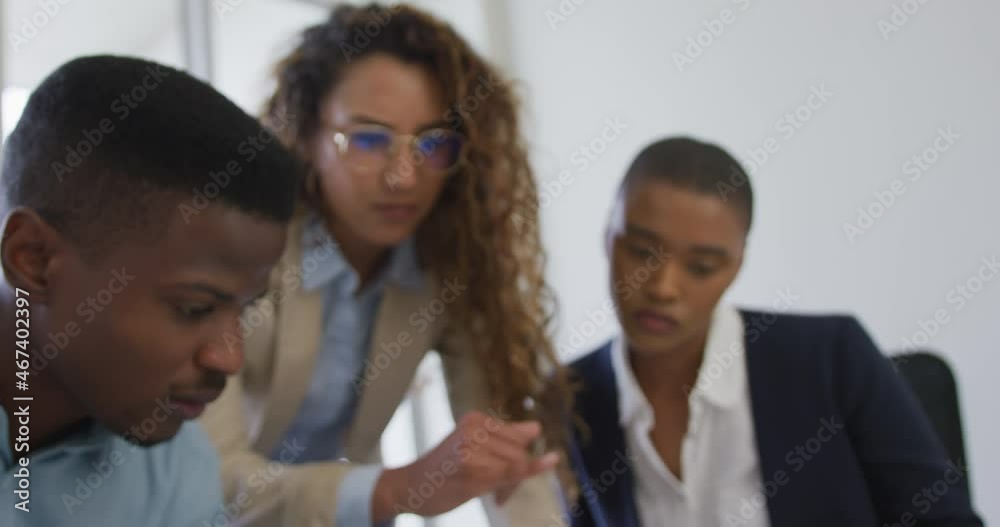 Biracial female and male architects talking and checking architects plans in modern office