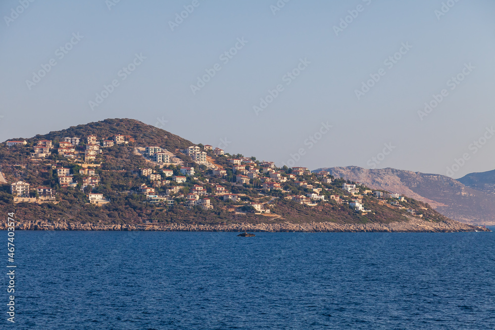 Cukurbag Peninsula with a large number of hotels and houses on a mountainous surface in the Mediterranean Sea in Kas Region, Turkey.