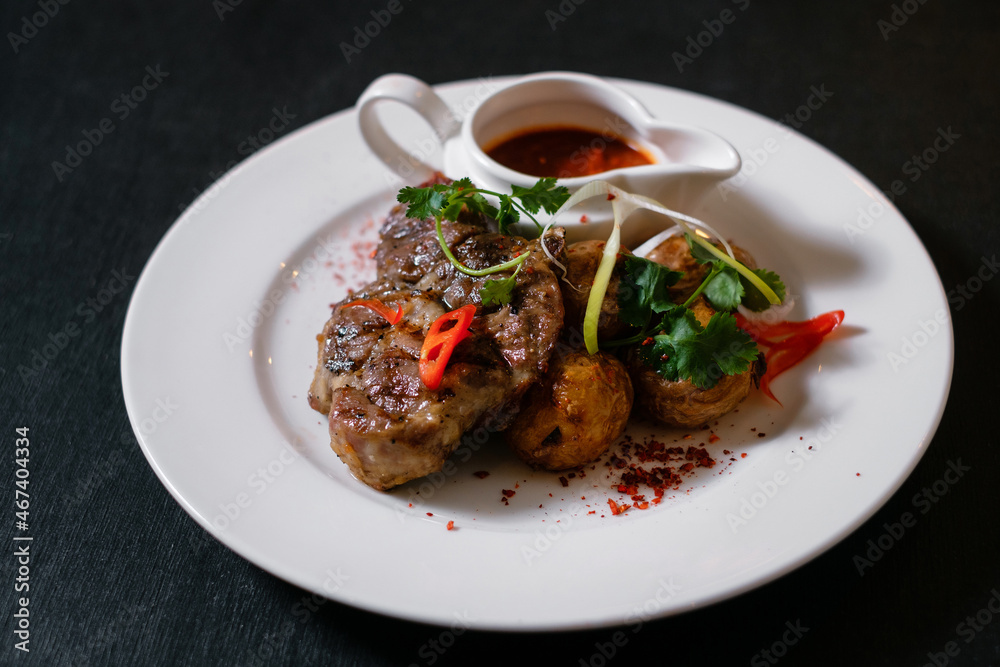Grilled pork with potatoes. Fried meat with sauce. Food cooking process. Grilled pork with potatoes. Fried meat with sauce. Food cooking process.