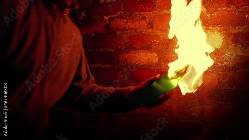 Anonymous Man Throws Molotov Cocktails By Brick Wall photo