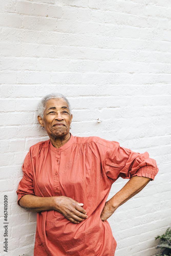 Naklejka premium Portrait of a mature black woman standing confidently against a brick wall