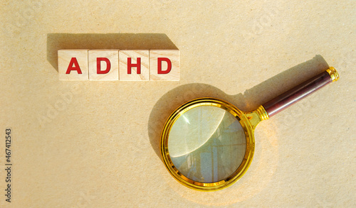 Wooden blocks ADHD and magnifying glass. Attention deficit hyperactivity synd...