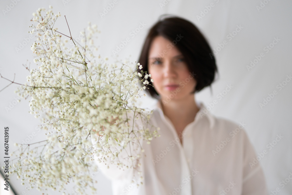 portrait of young beautiful woman with white bouquet in studio portrait of young beautiful woman with white bouquet in studio