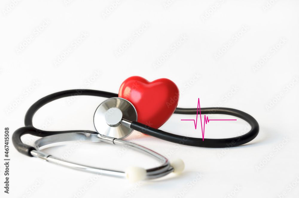 Mock up of a human heart with a phonendoscope and a fragment of a cardiogram on a white background close-up. Conceptual image for cardiology medical examinations or heart disease examinations. Mock up of a human heart with a phonendoscope and a fragment of a cardiogram on a white background close-up. Conceptual image for cardiology medical examinations or heart disease examinations.