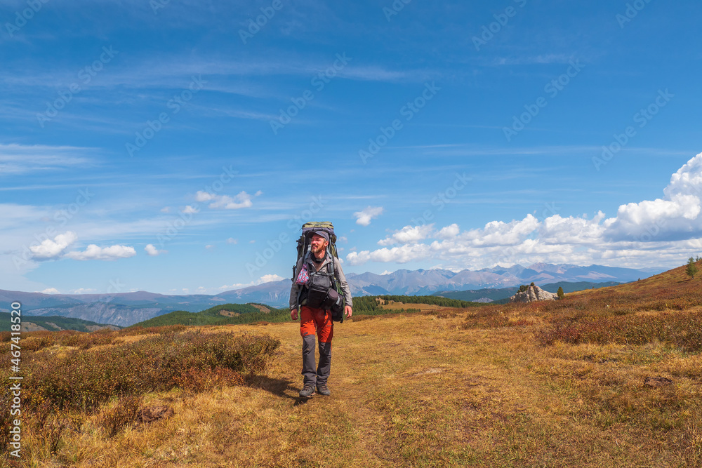 Happy solo traveler hiking in mountains, adventure solo traveling lifestyle concept, active weekend vacations on the wild nature.