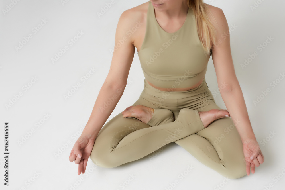 Woman in sportswear on a white background showing poses, exercises, mudras and yoga asanas. Woman in sportswear on a white background showing poses, exercises, mudras and yoga asanas.