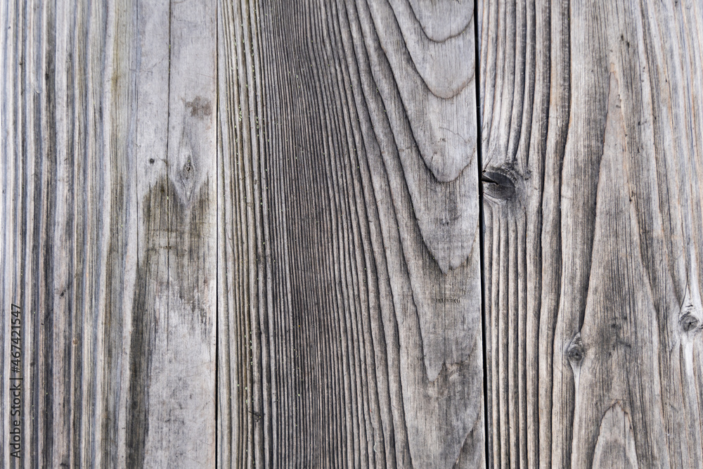 Grey wood planks texture background. Real wood grain backdrop with natural lines in the timber. Weathered flooring pattern as an abstract design structure. Grey wood planks texture background. Real wood grain backdrop with natural lines in the timber. Weathered flooring pattern as an abstract design structure.