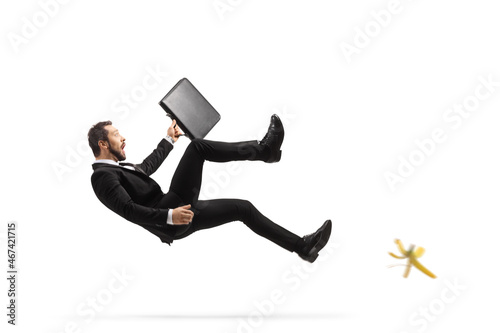 Foto Businessman with a briefcase slipping on a banana peel
